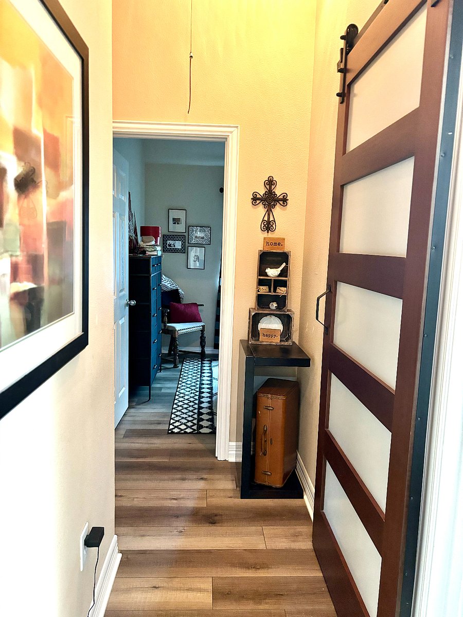 Hallway to secondary bedroom and bathroom with barn door into laundry room