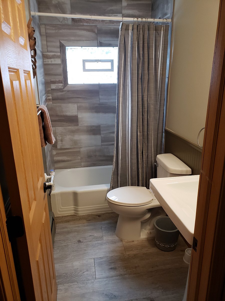 Bathroom with tile shower and glass block window for natural light.