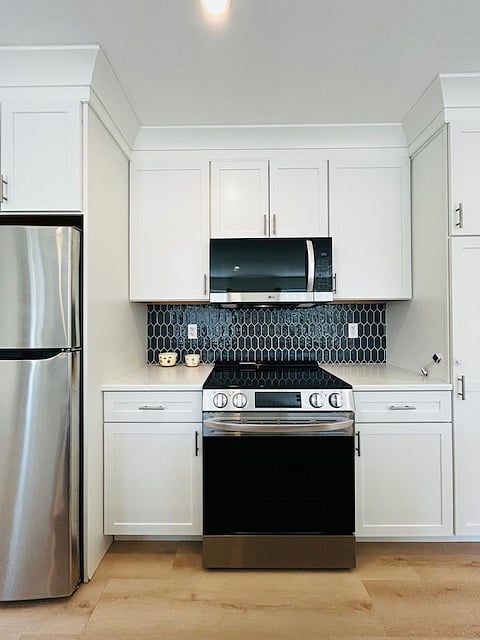 Luxury kitchenette with custom backsplash. Microwave vents outside for efficient air circulation.  