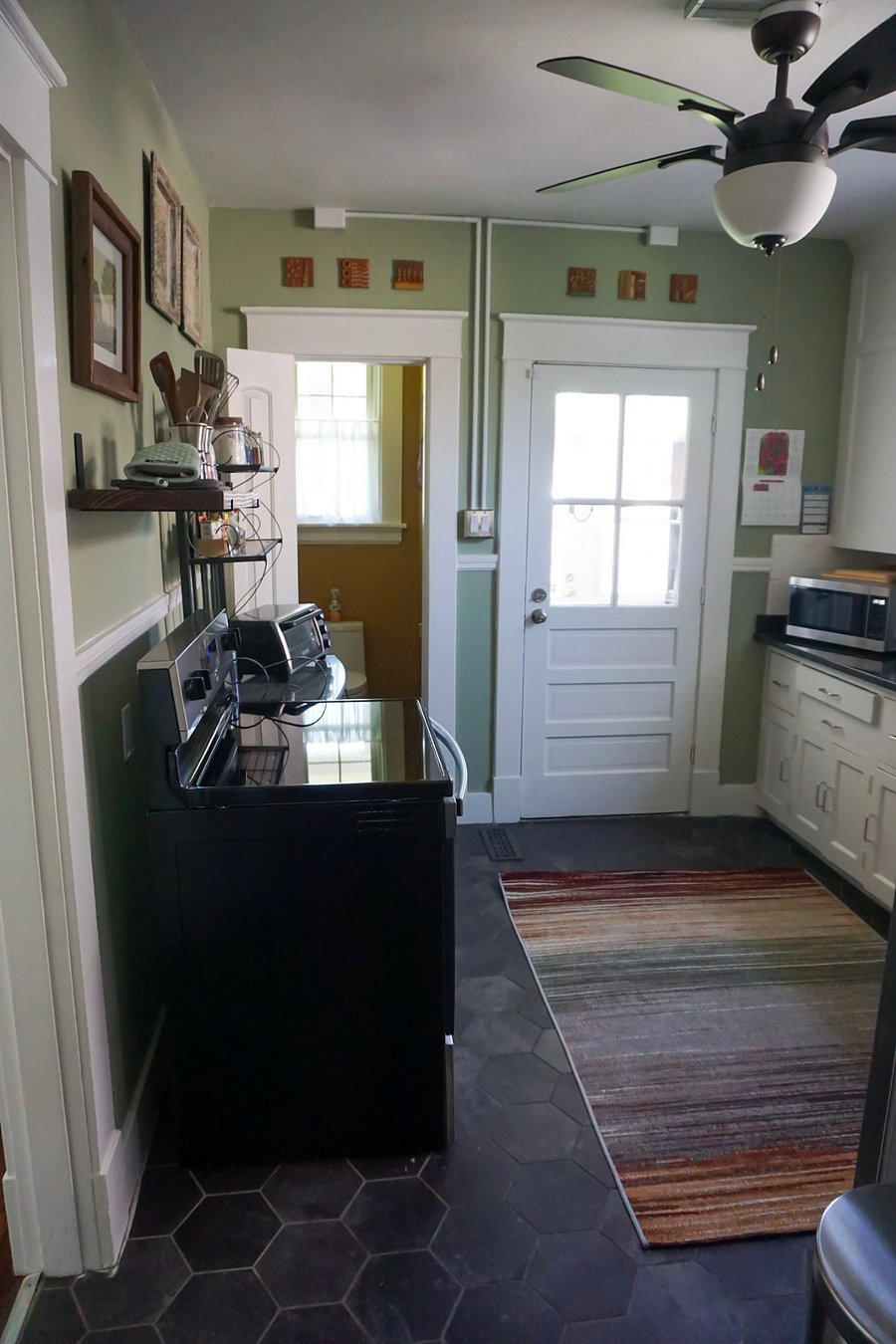 Kitchen: simple but well-appointed. View of the powder room and the door to the mud room and back yard.