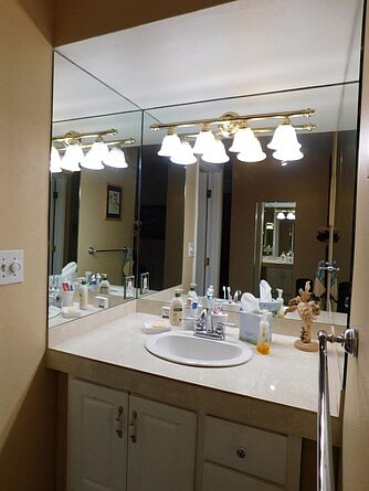 The bathroom vanity has an adjacent toilet/shower.