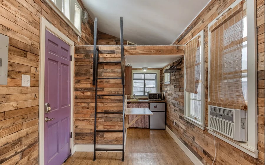 This is a separate unit with a separate yard. - Includes sleeping loft, tiny kitchenette, screened in porch, shower, toilet, private screen porch and private gate entrance.