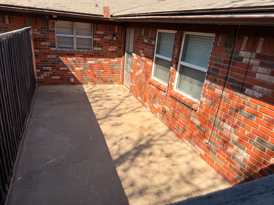 Patio in the rear of property.  Door leads to kitchen.  Gate leads to carport.