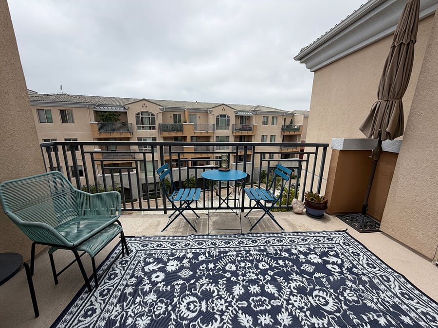 balcony gets western light, with bistro table, comfy chairs and hummingbird feeder.