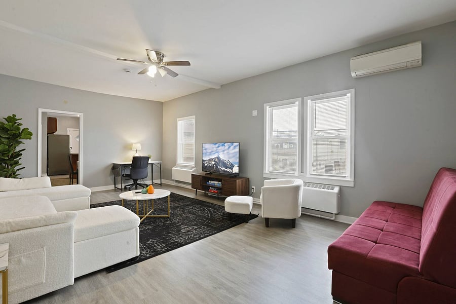 Living room. Includes: Couch, air conditioning, heating, TV, dedicated work table lamp, table and chair.