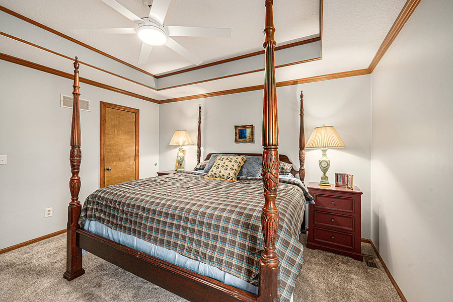 Cozy and stylish bedroom featuring a queen-size 4-poster wooden bed, perfect for comfort and a touch of timeless charm.