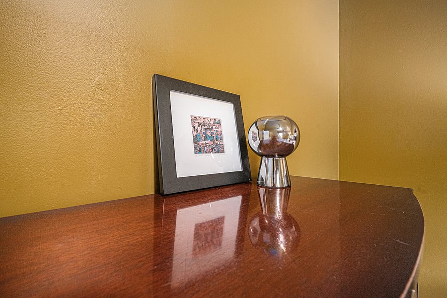 Decorative elements on the cabinet, including a painting and curated display, bring charm and a cozy, polished feel to the space.