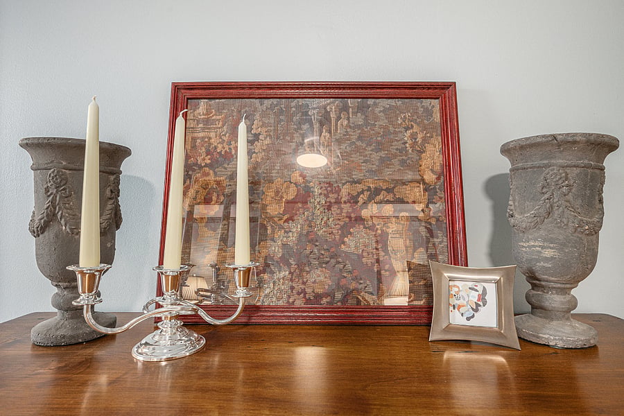 Decorative elements on the cabinet, including a painting and curated display, bring charm and a cozy, polished feel to the space.