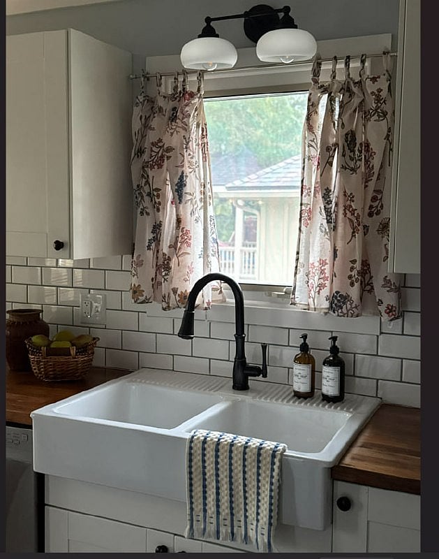 A charming kitchen sink with dual taps set beneath a window, offering a pleasant view and natural light while you wash and prep.
