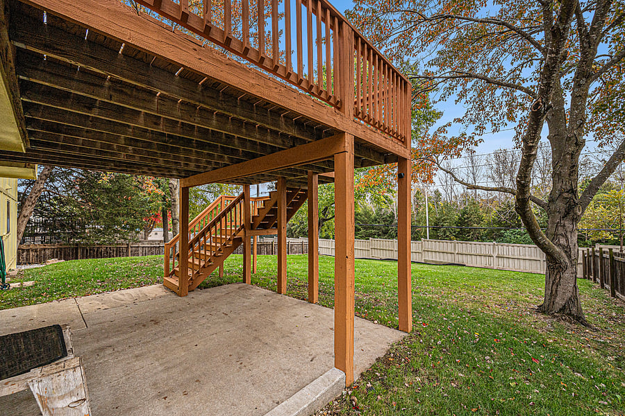 A versatile deck with stairs leading to the backyard, perfect for outdoor meals or gatherings, with a shaded patio underneath for relaxing or entertaining.