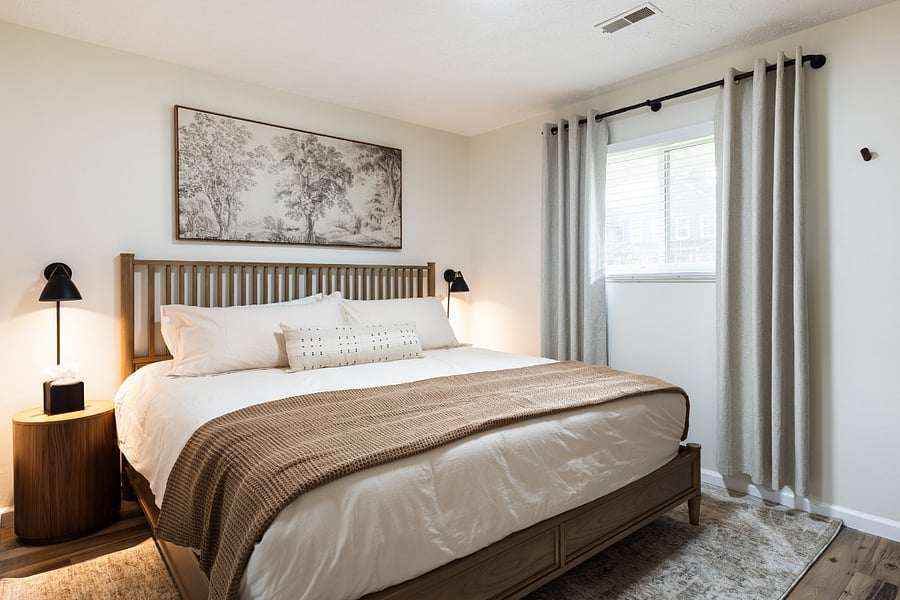 Primary bedroom with a king memory foam bed, blackout curtains, and nightstands