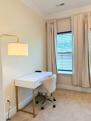 Dedicated workspace equipped w/ a desk, working chair, lamp and power strip that has outlets, USB and USB-C ports. 