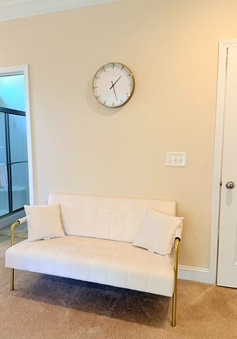Loveseat & wall clock in master suite