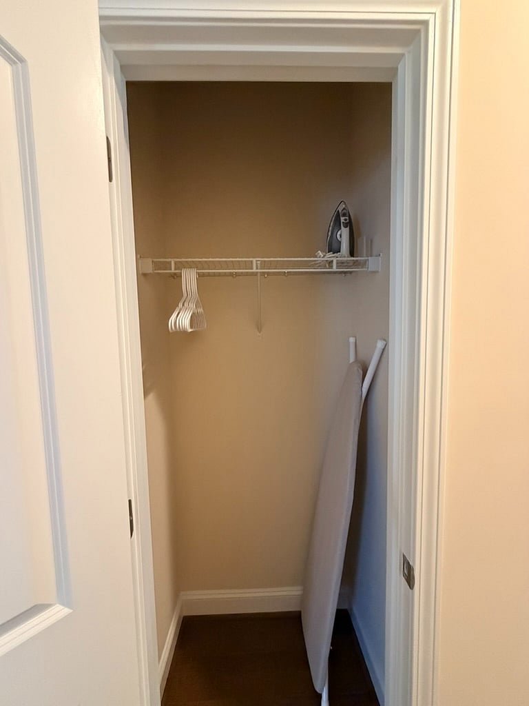 Coat closet w/ ironing board & iron.
