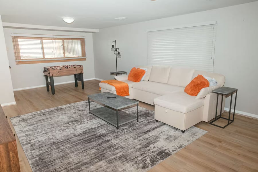 Furnished basement with Smart TV, sleeper couch and game area.