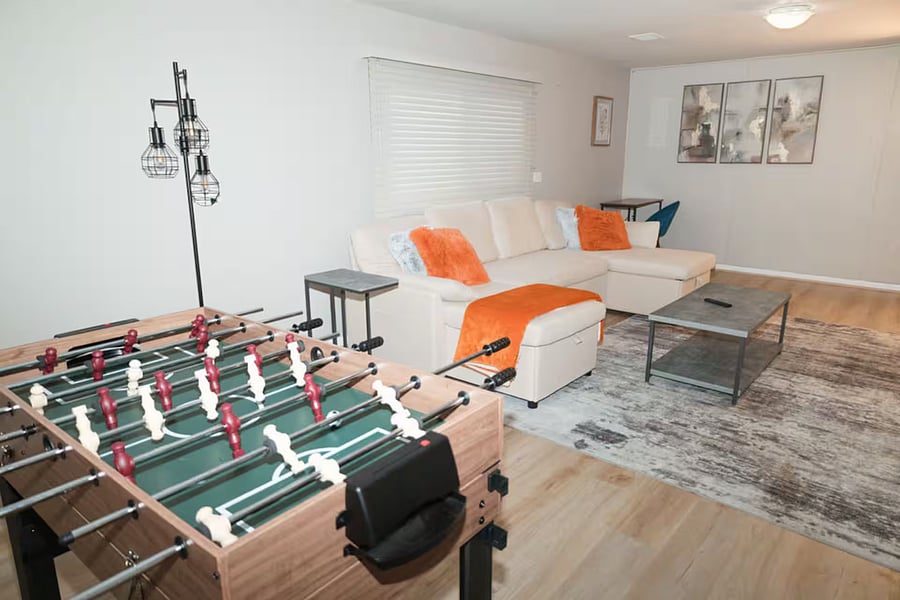Furnished basement with Smart TV, sleeper couch and game area.