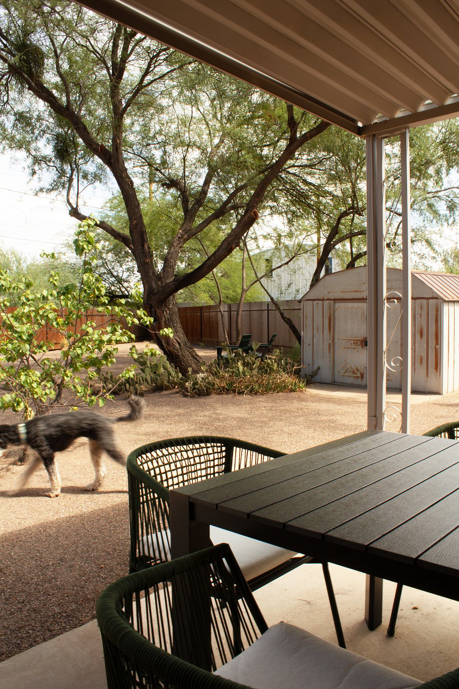 Covered patio with outdoor dining furniture and grill.