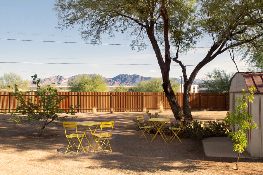Private fenced backyard with shaded seating and mountain views.