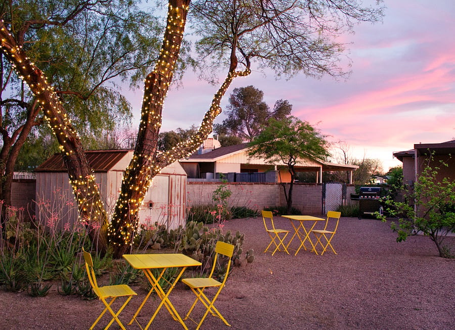 Private backyard with seating, string lights, and sunset views.