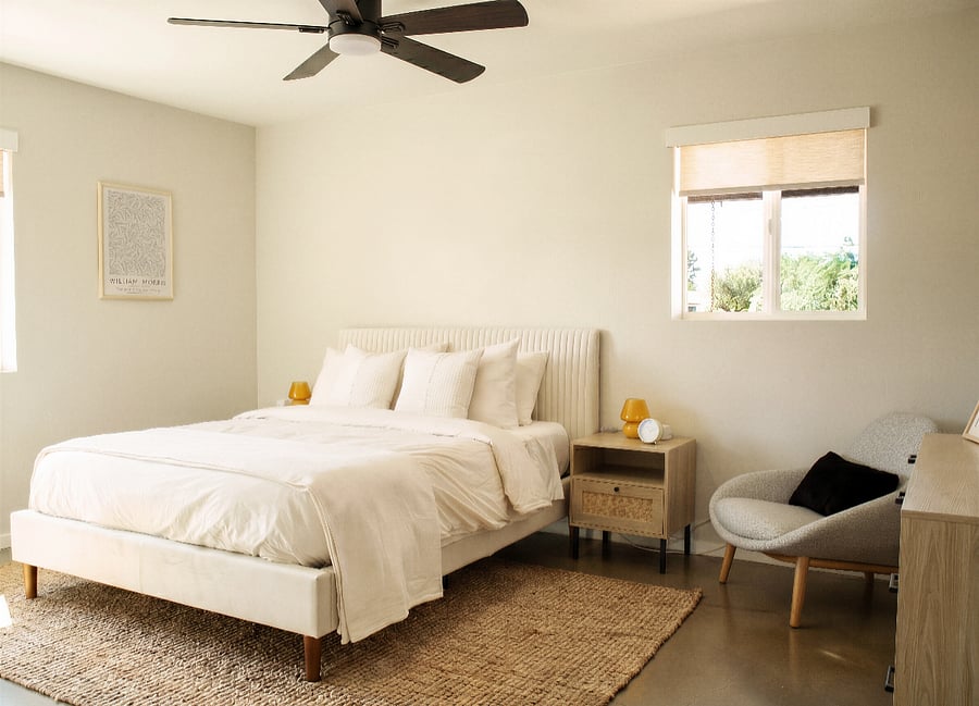 Bright bedroom with queen bed and seating area.