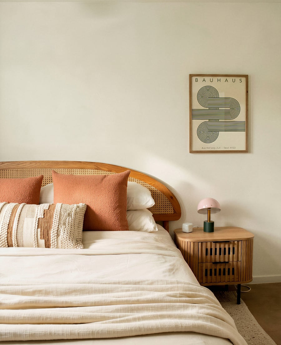 Serene primary bedroom with warm wood accents, layered textures, and a calm, modern aesthetic
