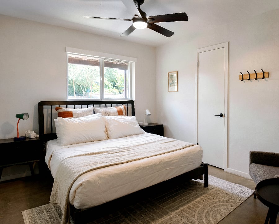Peaceful queen bedroom with garden window views and warm desert accents.