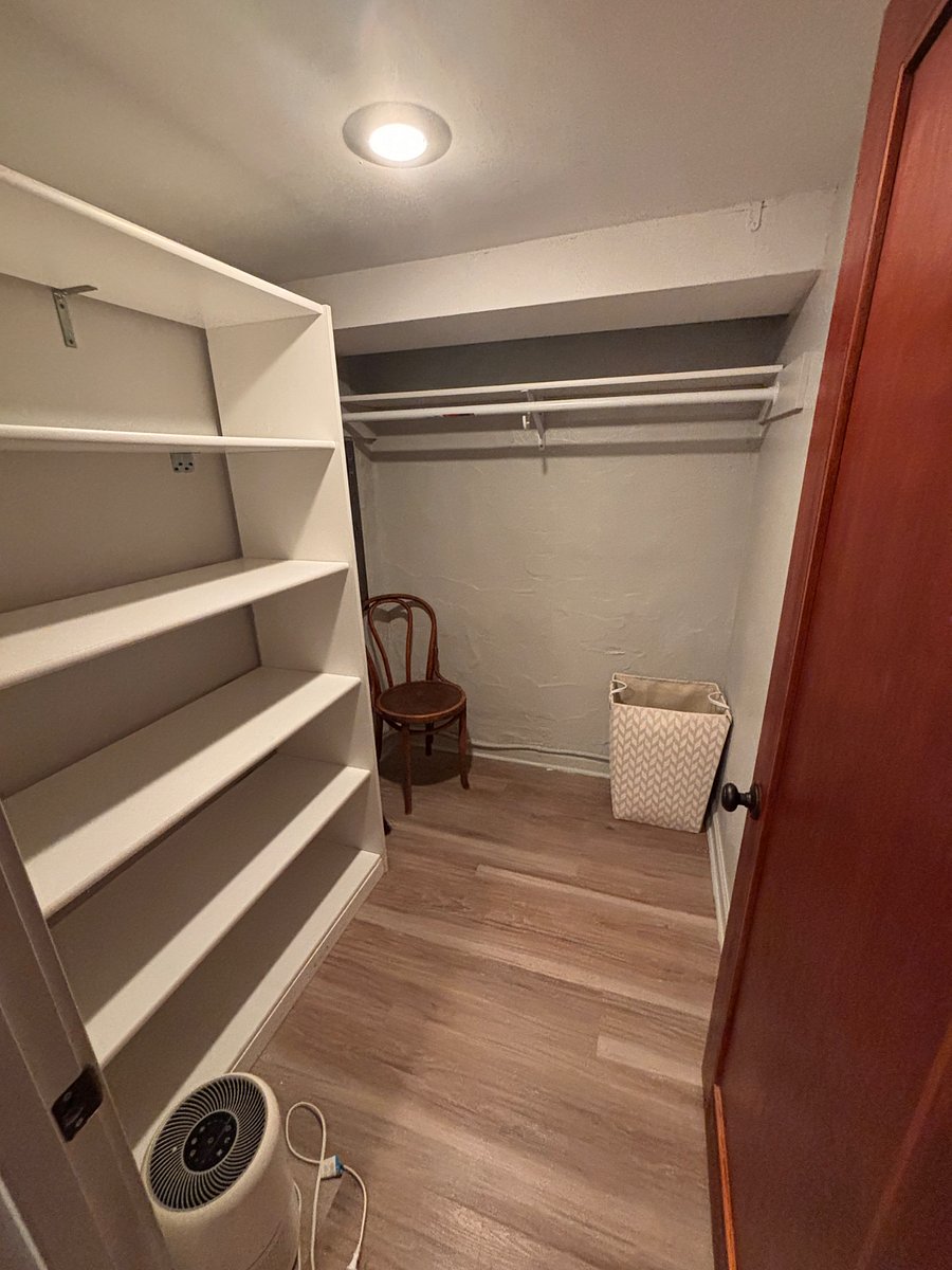 Walk in bedroom closet with shelving and hanging options.