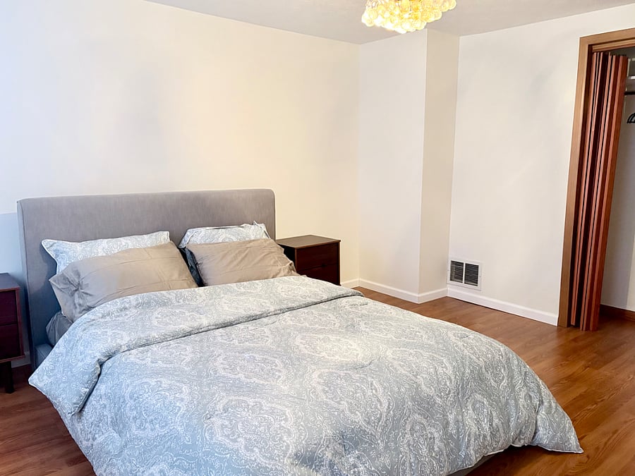 Bedroom with queen bed featuring new mattress and pillows.