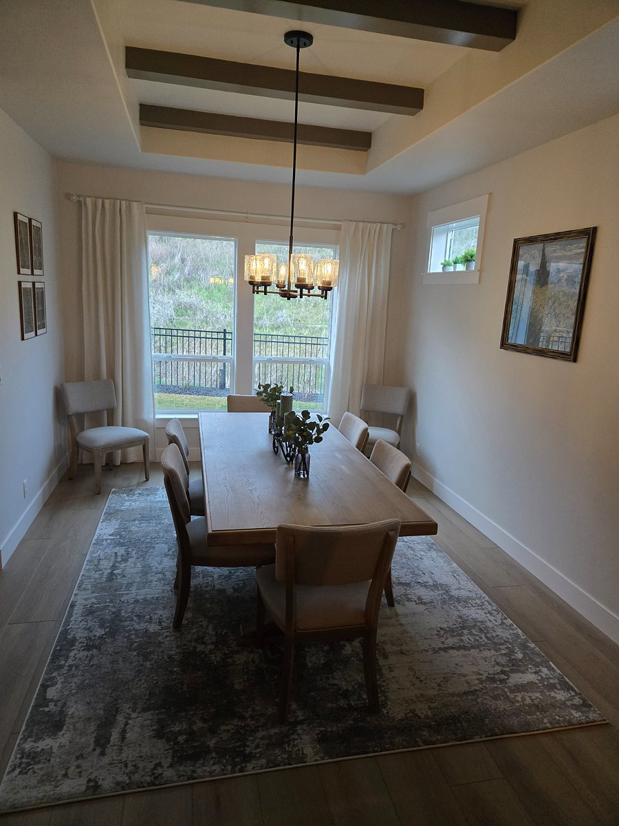 The dining room offers a view of the private backyard, providing a peaceful and scenic backdrop of nature right outside your window.
