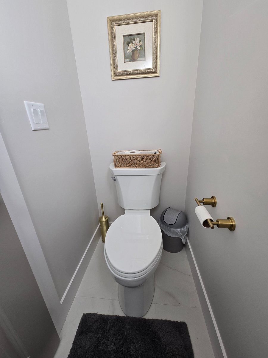 The master bathroom features a private toilet room with a window and door for added privacy.
