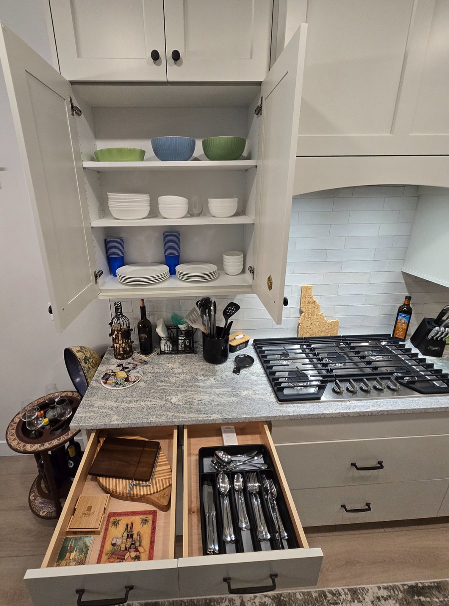 The kitchen is turnkey ready to meet all your needs, with dishes, silverware, glasses, a cheese board, coasters, and more, all set for your convenience.