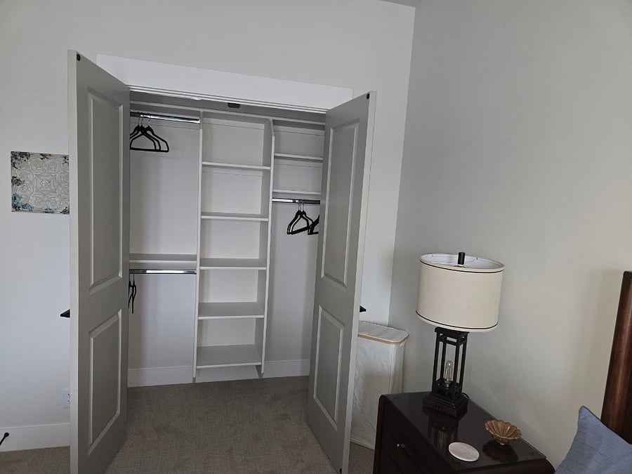 A view of the closet, showcasing its built-in organizers and spacious interior designed to keep your clothes and belongings neatly arranged and easily accessible.