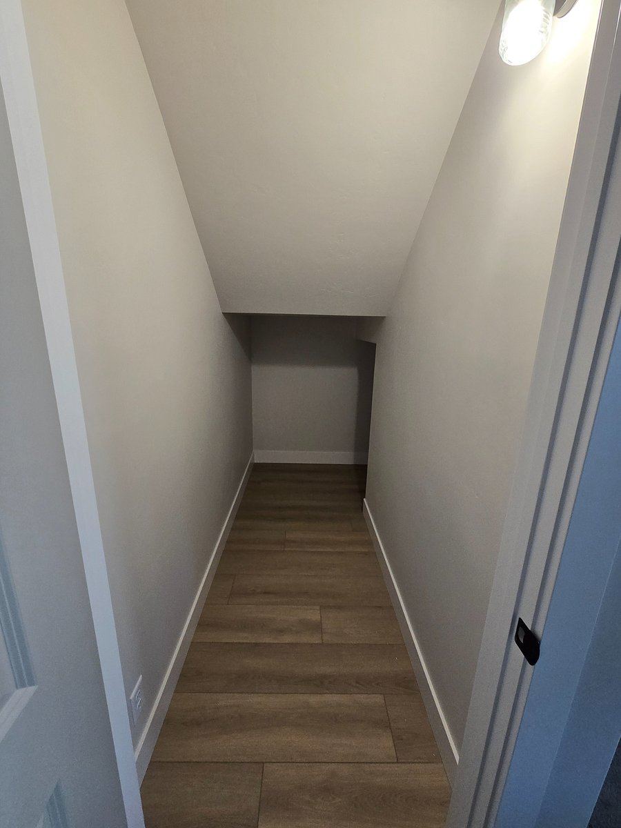 Additional storage space is available under the stairs, perfect for storing larger items such as seasonal decorations, luggage, or bulky household supplies, helping to keep the main living areas organized and clutter-free.