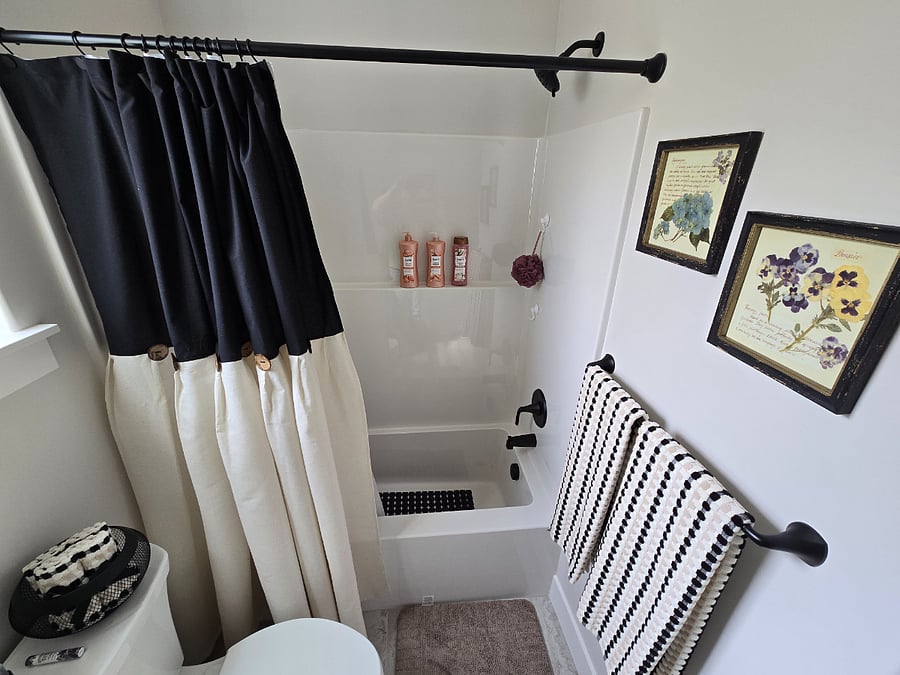 View into the shower, with toiletries and products neatly arranged and ready for use.