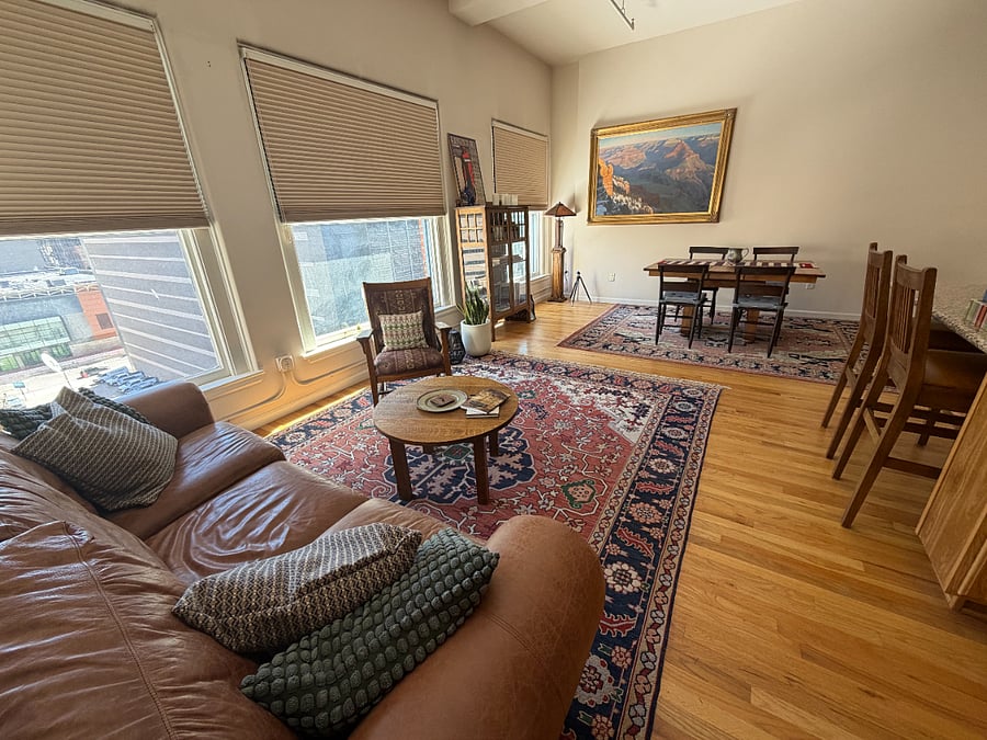 Open living/dining area with oversized loft windows looking out over downtown Denver.