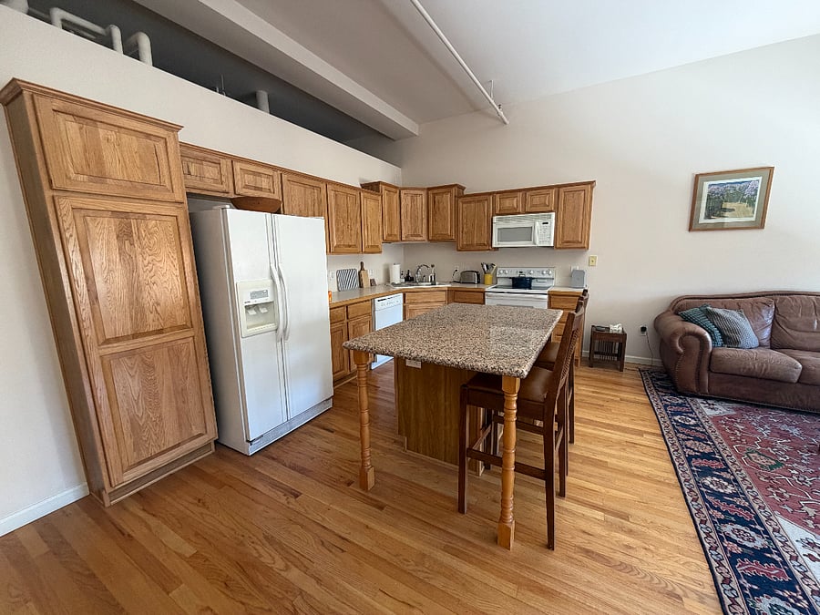 Fully equipped kitchen with fridge, microwave, coffee maker, stove and dishwasher.