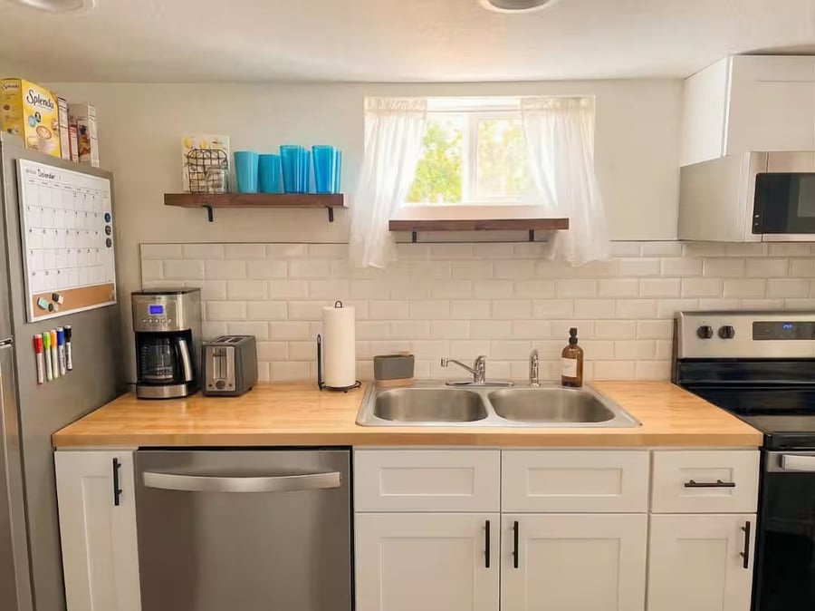 Fully equipped kitchen with butcher block counters, coffee maker, toaster, and dishwasher.