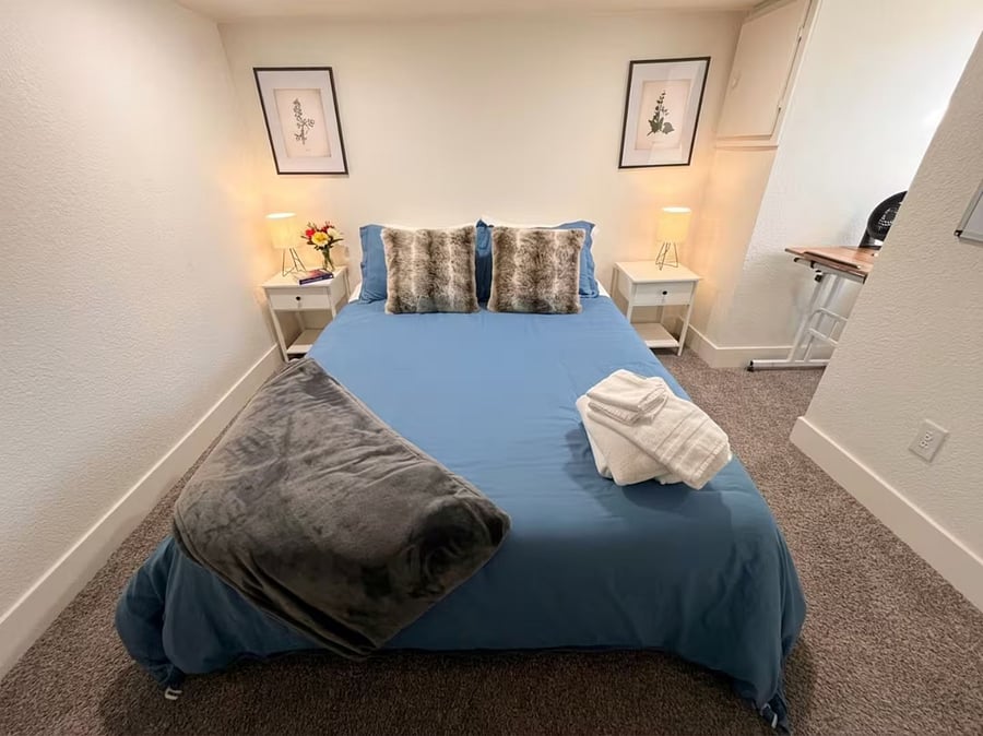Queen bed with cozy bedding and workspace access.