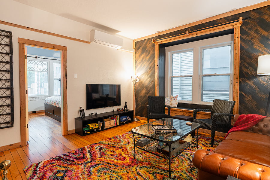 Living Room - High ceilings, electric fireplace, wood floors, bigscreen TV, and large windows seat.