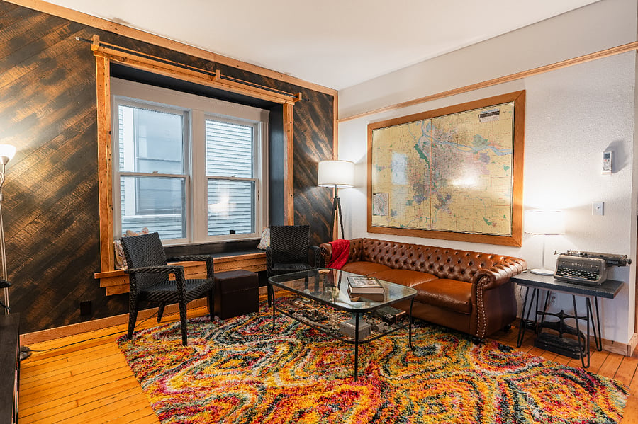Living Room - High ceilings, electric fireplace, wood floors, bigscreen TV, and large windows seat.