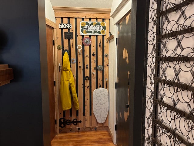 Entry - has coat rack, high ceilings wood floor, and coat closet.