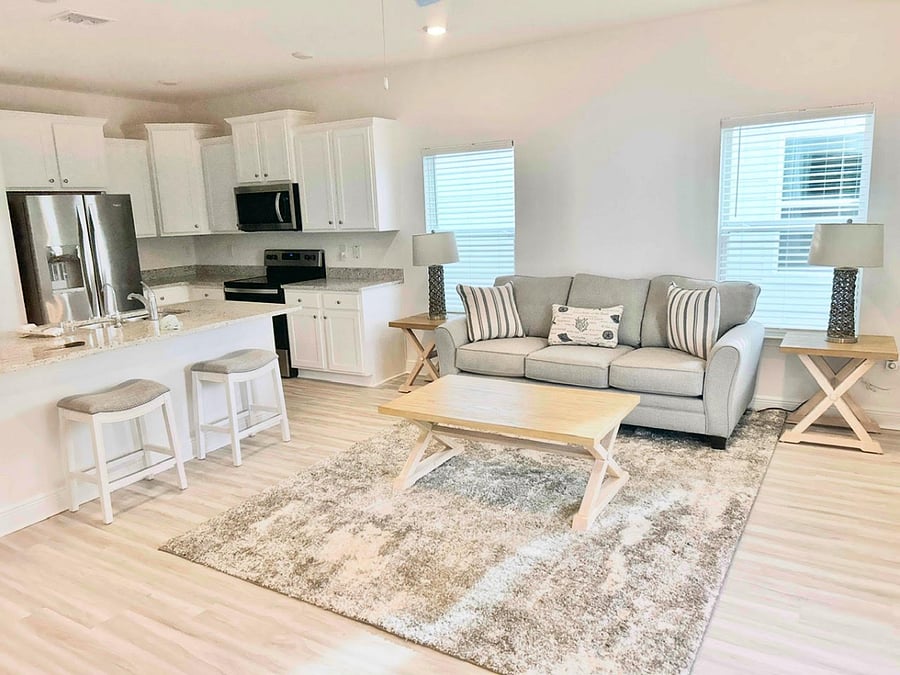 Family room / kitchen with couch, tables, lamps, and stools.