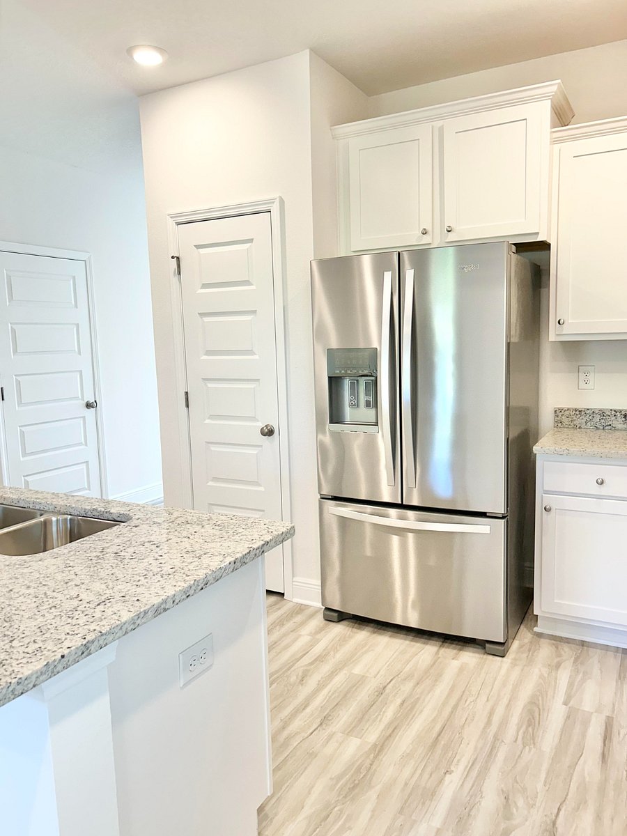 Kitchen area with full sized refrigerator and pantry.
