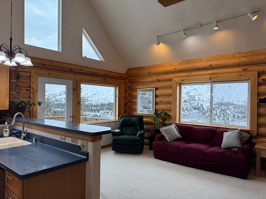 Living room adjacent to kitchen and breakfast bar with seating