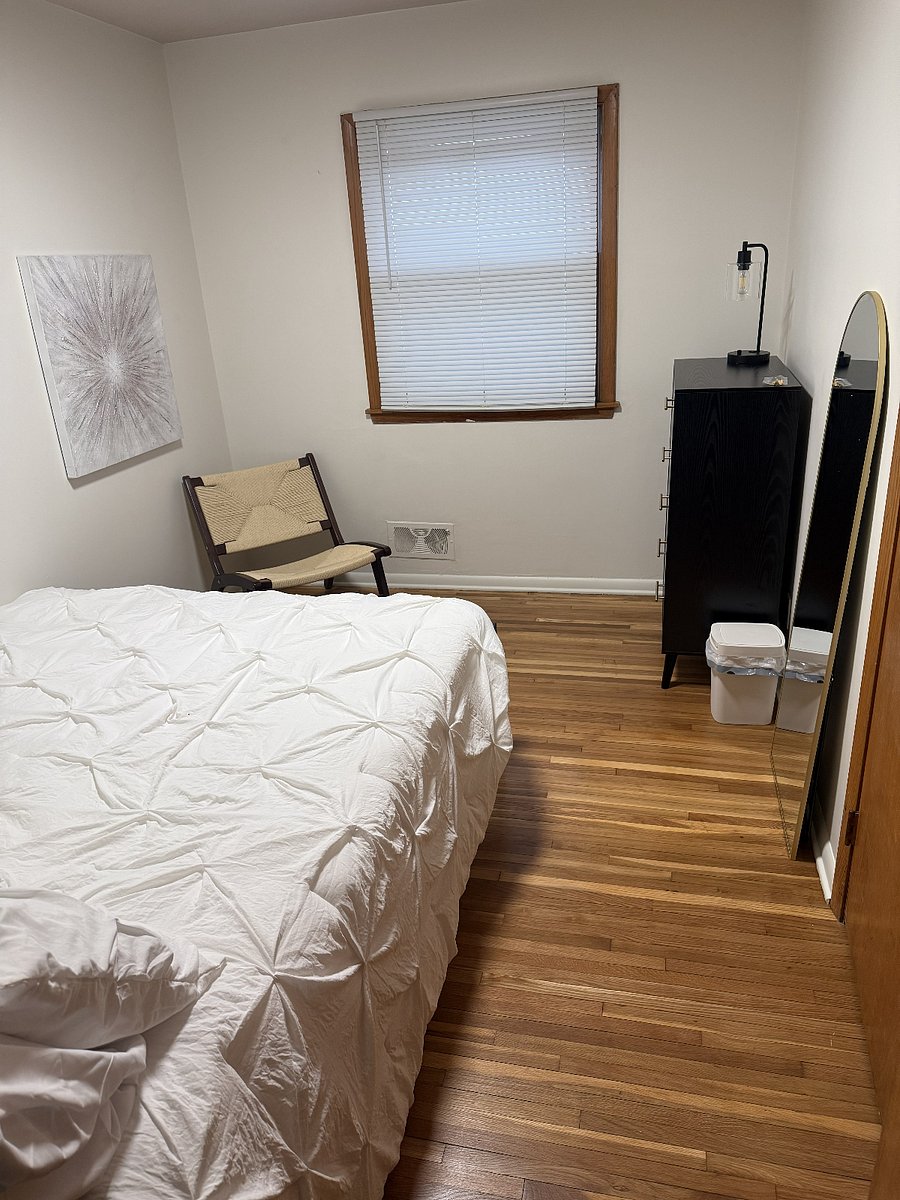 The second bedroom featuring a queen bed, dresser, and a comfy lounge chair!