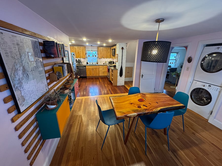 This shows the shared kitchen and dining room, the living room is over to the right. The stairs up to the second level are just behind the brick chimney.