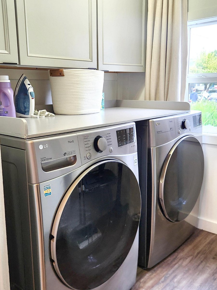 Laundry Room with washer, dryer, vacuum, broom, and mop.