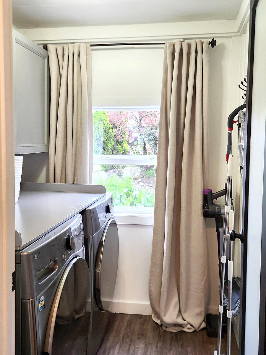 Laundry Room with washer, dryer, vacuum, broom, and mop.