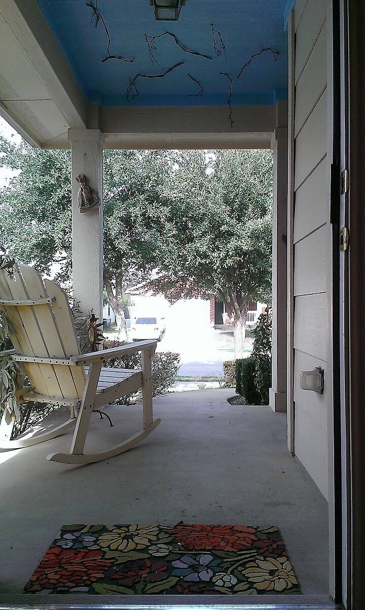 Rocking chair overlooking front native plants that attract hummingbirds and butterflies.