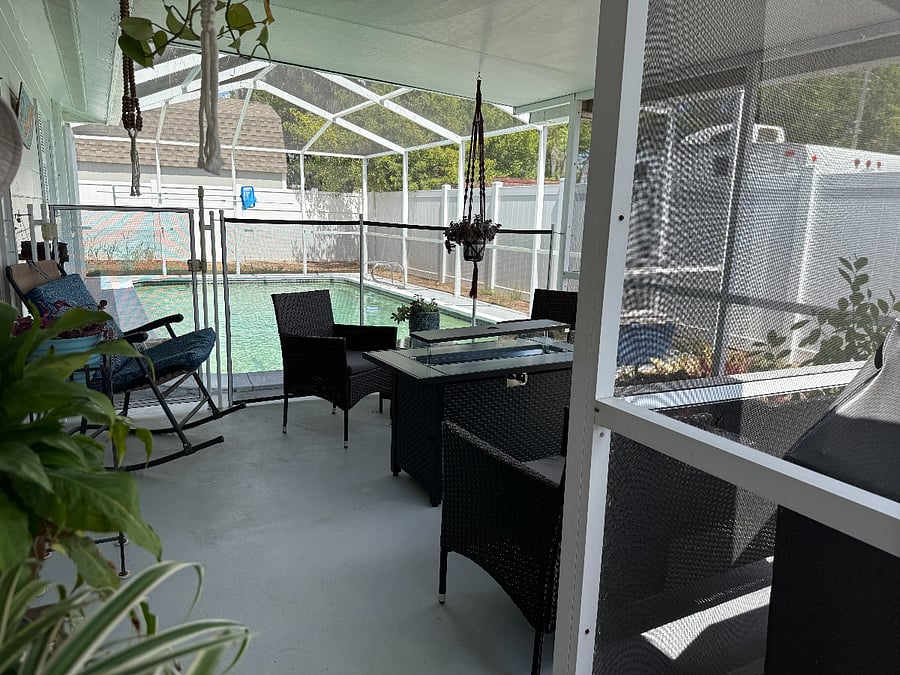 Spacious back porch with seating overlooking the in-ground pool